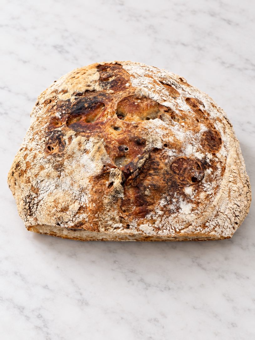 A round Country Blonde with Pecan loaf on a marble counter.