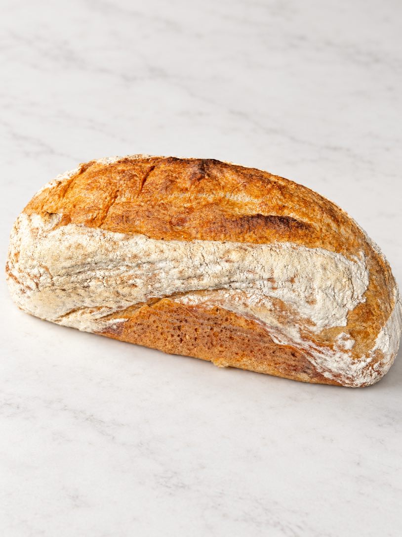 A long Double-Fed Sweet Levain loaf seen from the side.